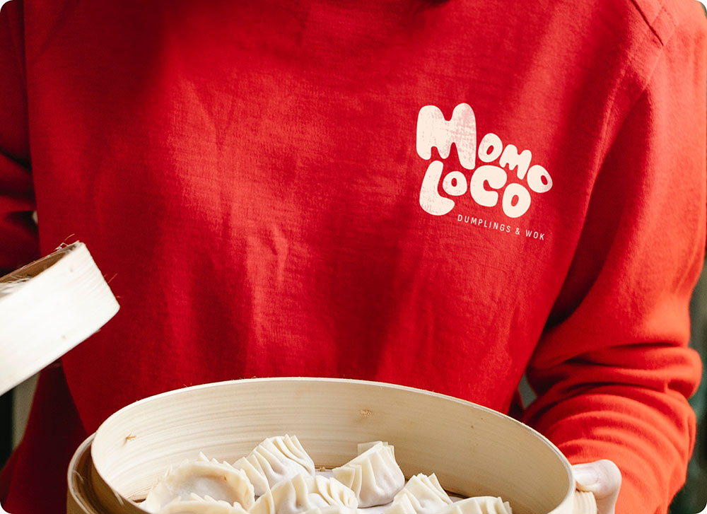 a person holding a bowl of dumplings