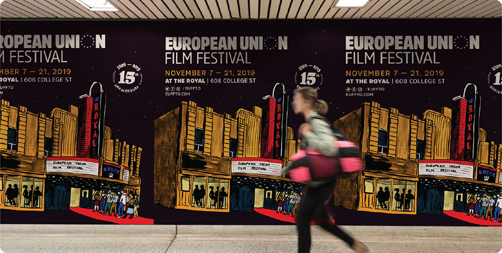 a woman walking in front of a poster