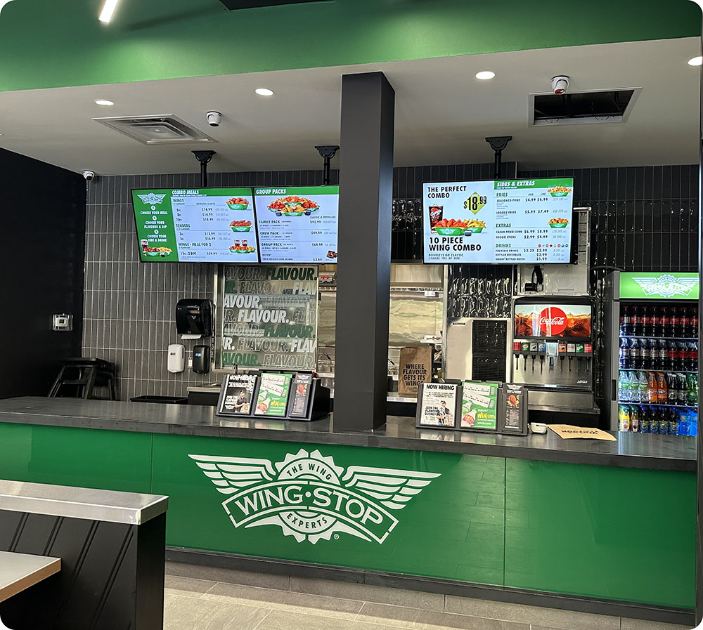 a green counter with signs and a drink stand