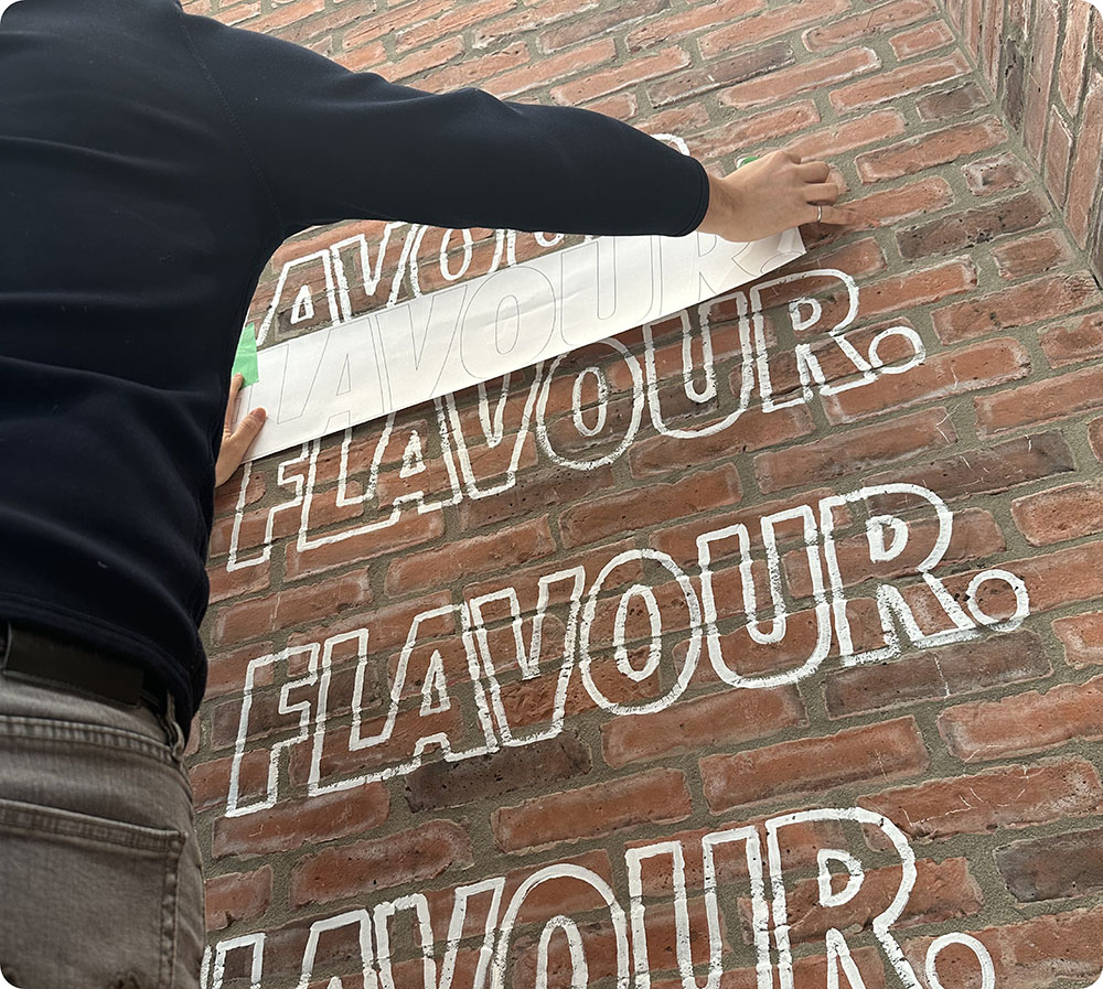 a person writing on a brick wall