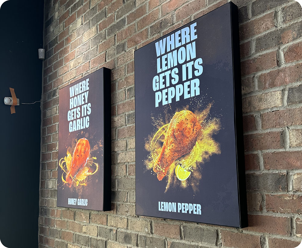 two posters on a brick wall