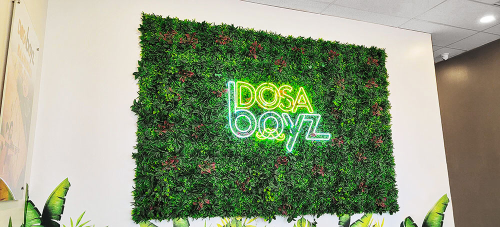 a green plant with a neon sign