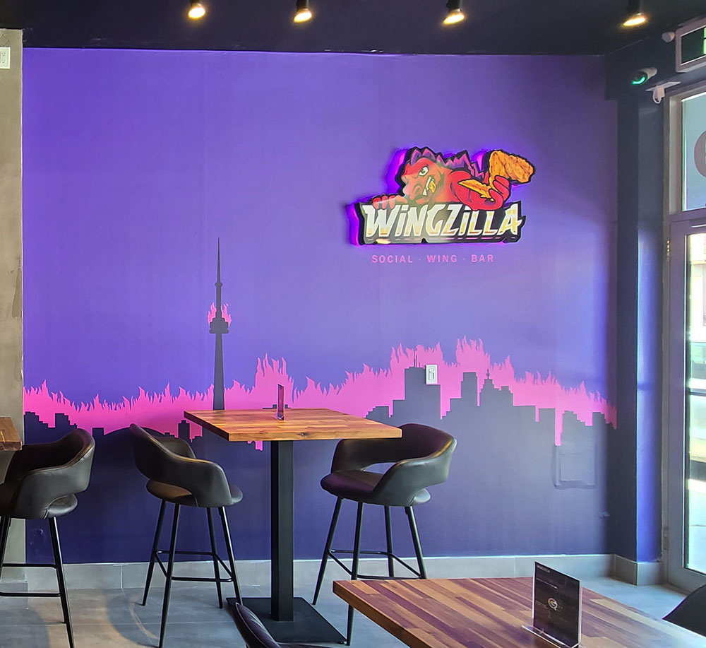 a purple wall with chairs and tables