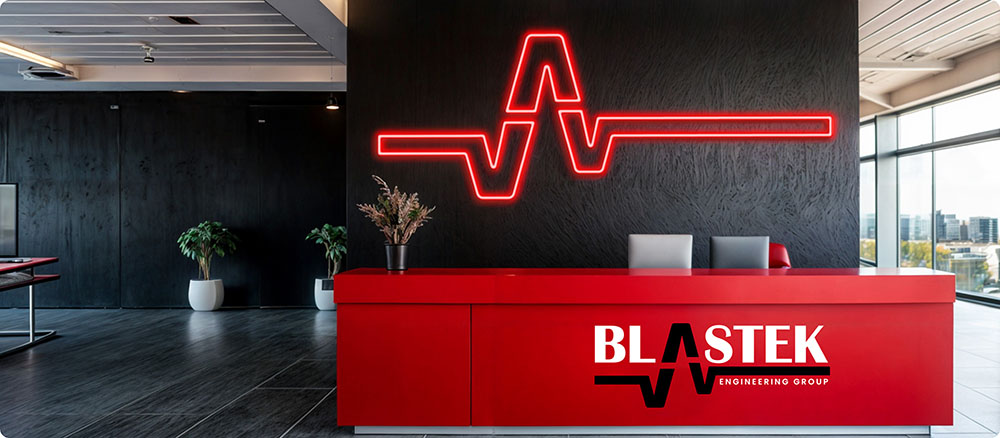 a red reception desk with a logo on the wall